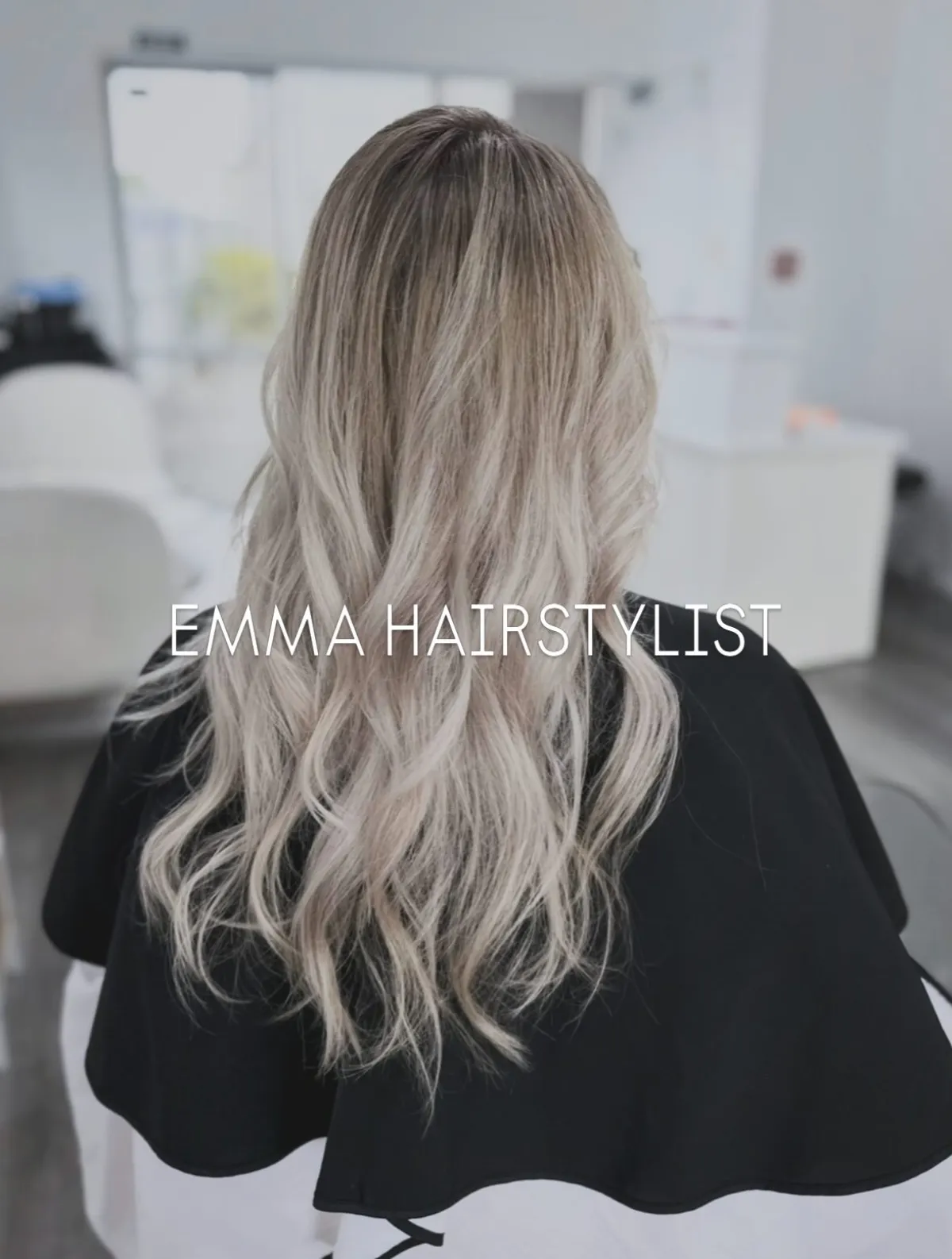 Long hair in a cool platinum air-touch balayage, softly waved, at Emma Hair Stylist