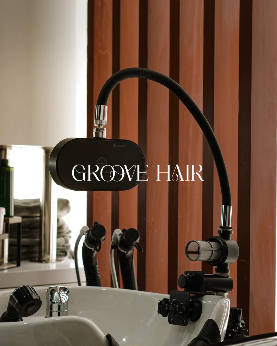 A head spa shower unit mounted above a wash basin at Groove Hair